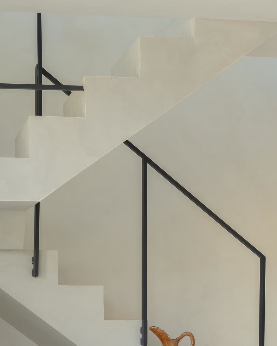 Black steel stair rail over microcement